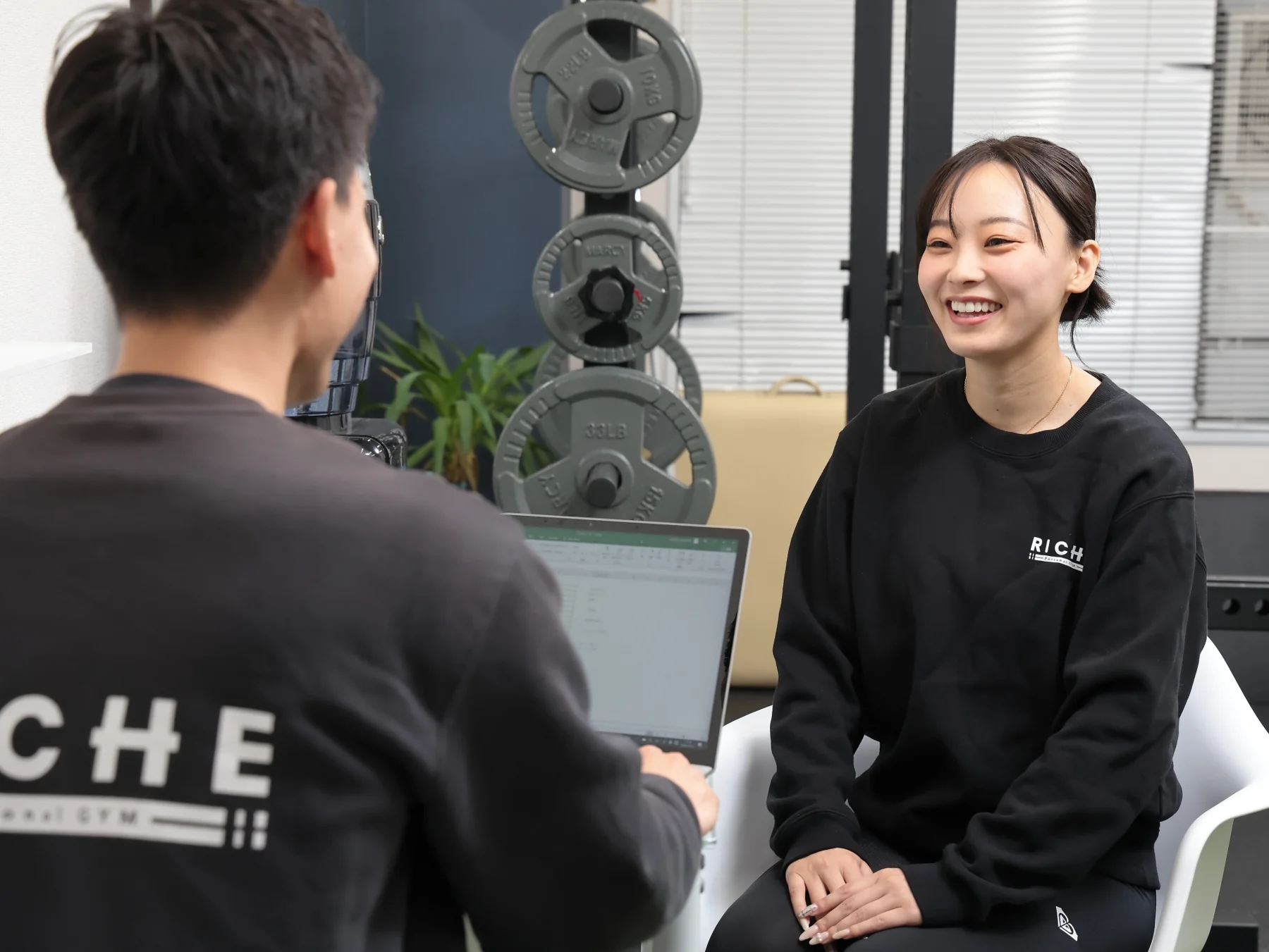 トレーナーと目標を話す女性のお客様
