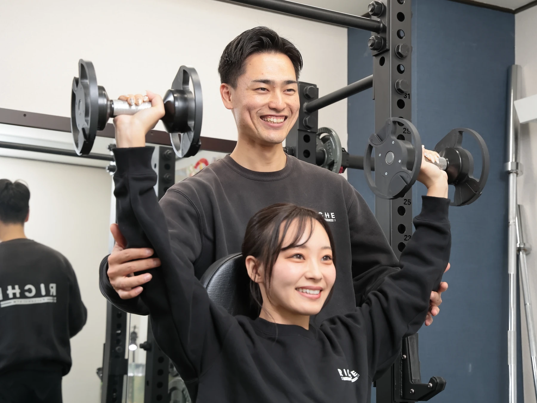 RICHEのトレーナーと笑顔でトレーニングする女性
