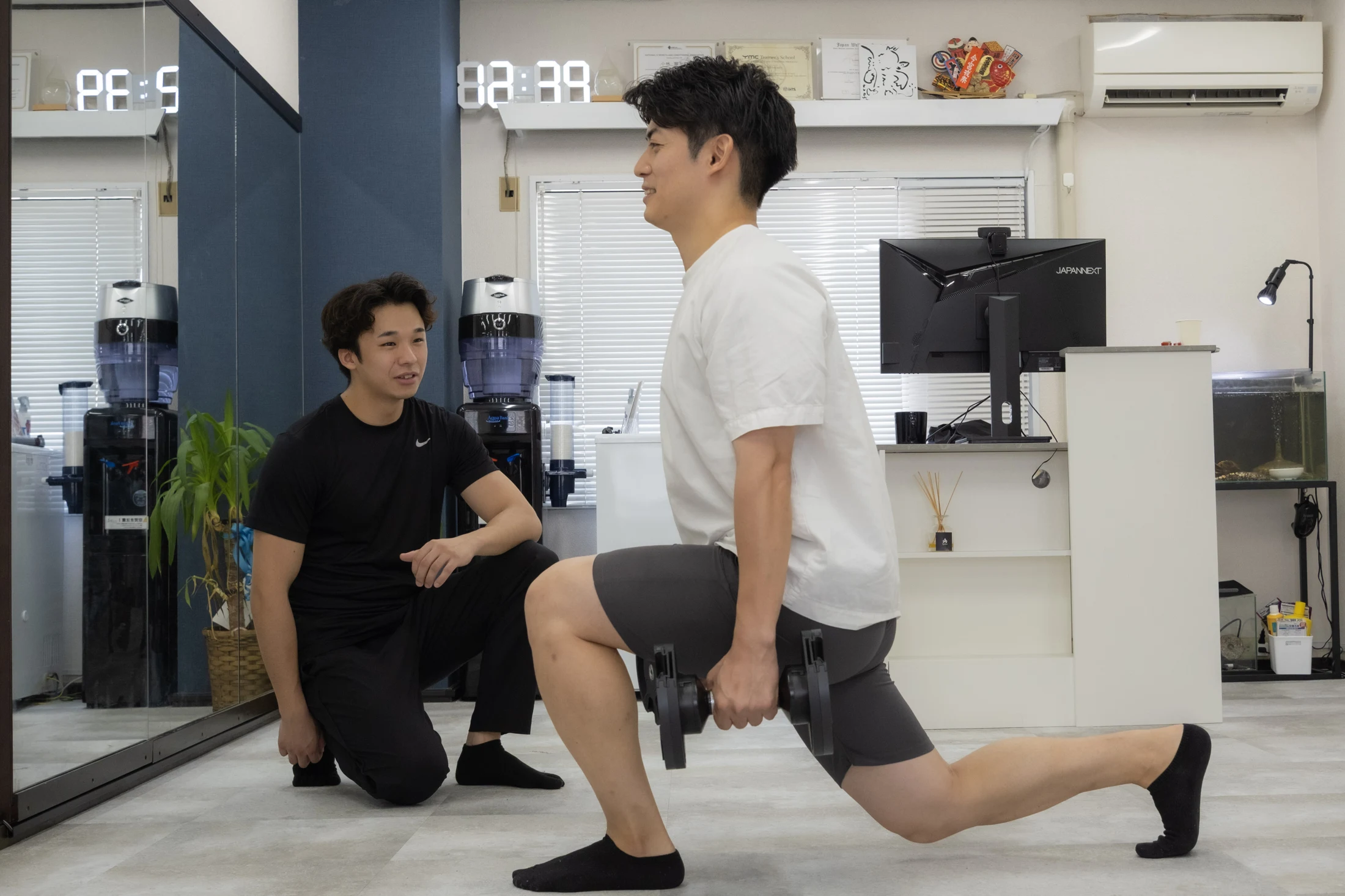 グレー床の店内でランジに取り組む男性のお客様